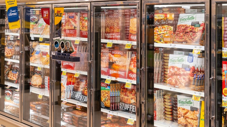 Various frozen pizza brands in grocery store frozen section