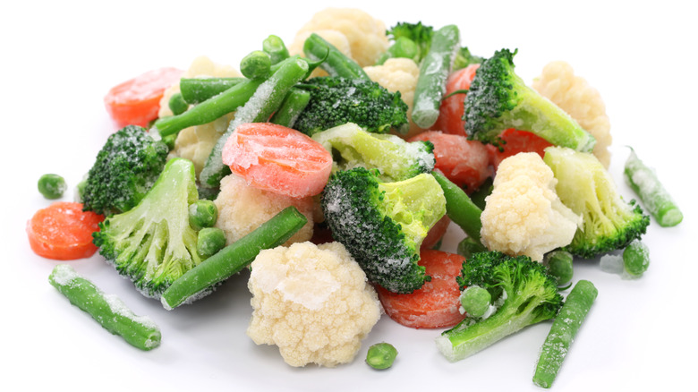 Frozen broccoli, carrots, beans, and cauliflower on a white background