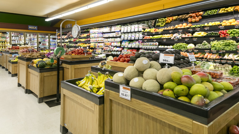 Grocery store produce section with fruits and vegetables stacked up.