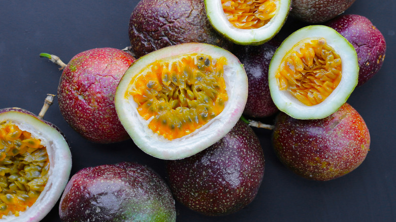 Passion fruit halves and whole fruit on a table
