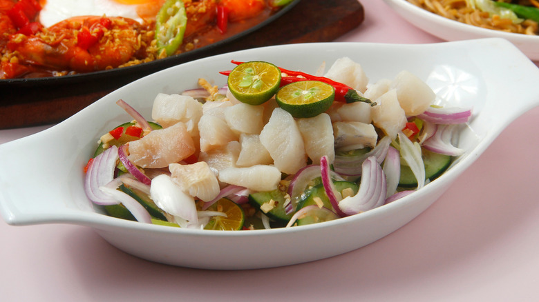 A white dish of fish ceviche with calamansi served on a table.