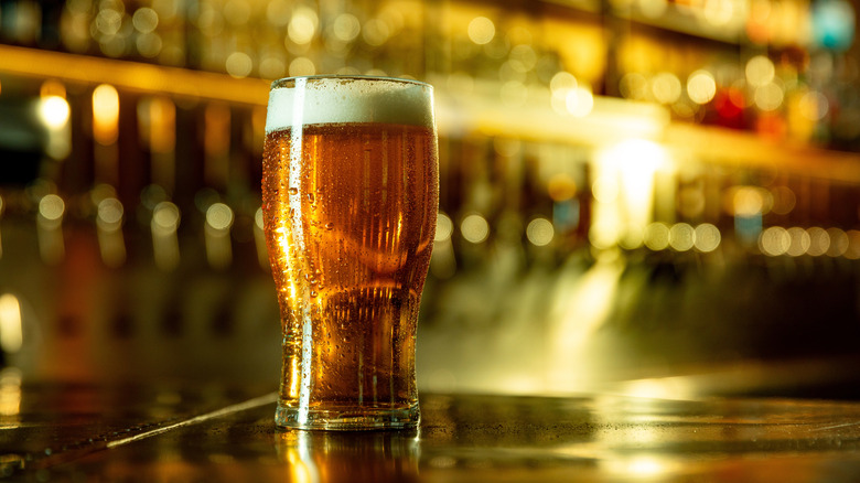 A pint of amber-colored beer on a bar