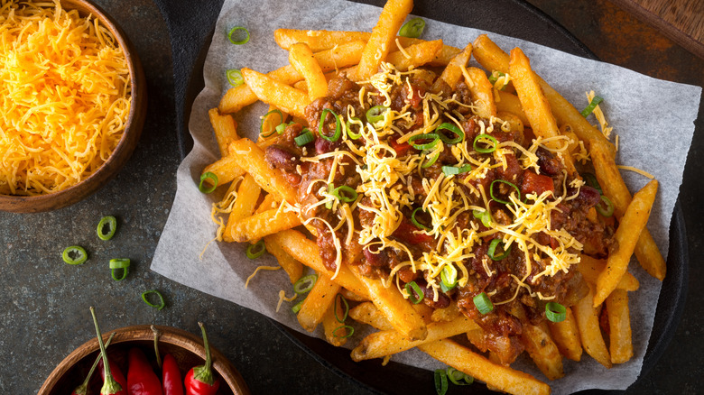 Chili cheese fries with shredded cheese and green onion