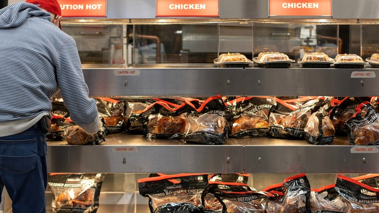 Costco customer picking out a rotisserie chicken