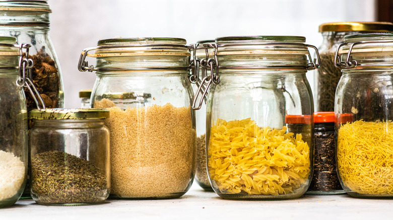A row of Mason jars containing dry goods