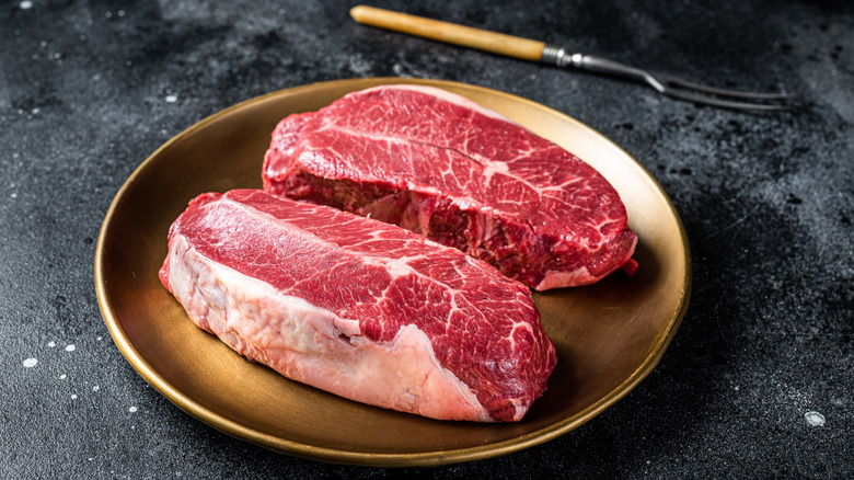 two raw steaks on a plate