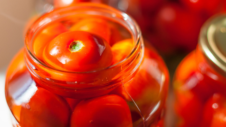 tomatoes being canned in mason jars