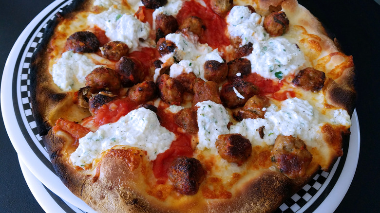 pizza topped with ricotta and meatballs