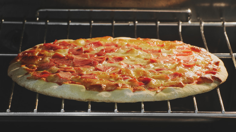 pizza cooking on oven rack