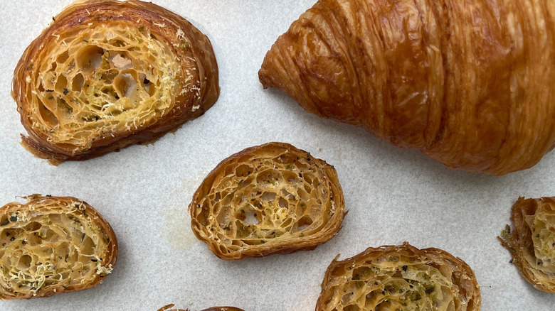 Seasoned croissant croutons next to full-sized croissant