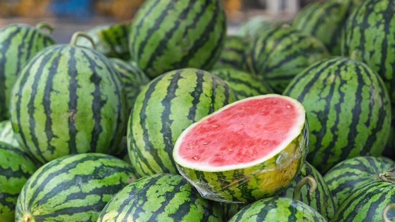 Fresh watermelons at a fruit stand.