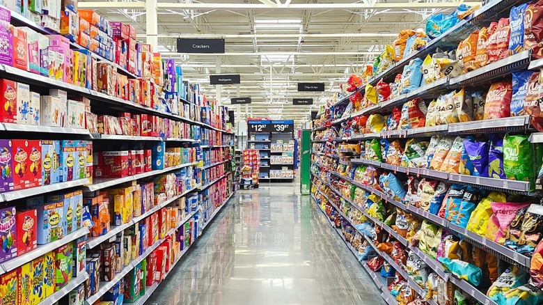 A supermarket aisle with snacks and chips on the shelves.