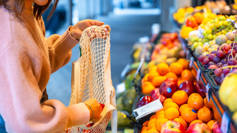 Person putting produce in a mesh bag