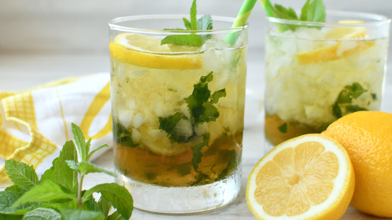 A cocktail in a short glass made with a lemon garnish.