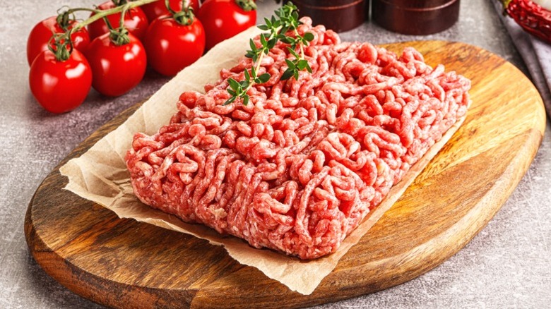 Uncooked ground beef on a wooden cutting board.