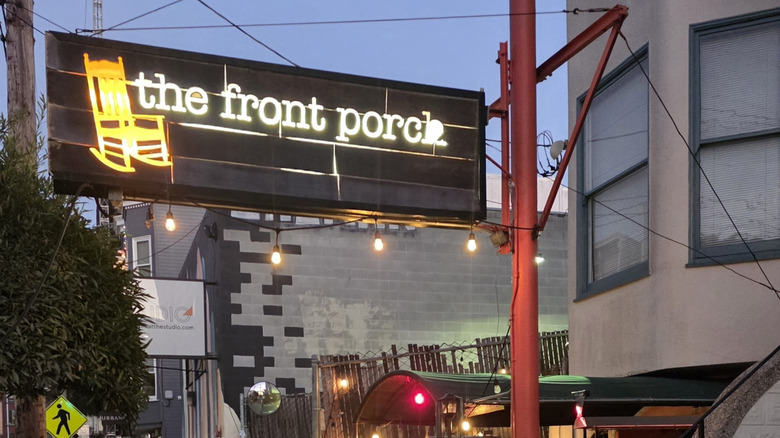 An exterior view of The Front Porch restaurant with lit-up sign