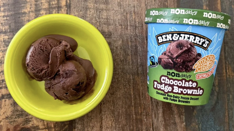 Top down view of Ben & Jerry's non-dairy Chocolate Fudge Brownie scoop in bowl with packaging next to it.