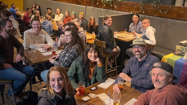 Crowded interior of Von Ebert Brewing dining room with customers smiling and looking at camera