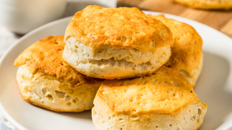 Biscuits stacked up on a white plate.