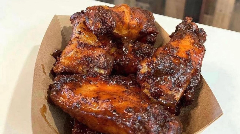 Paper container of chicken wings on a white table