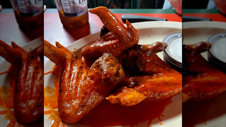 Pile of whole buffalo wings on a white plate with ranch