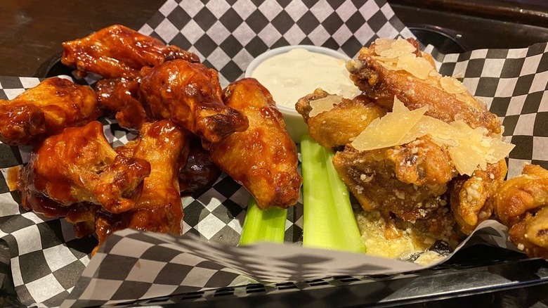 Two types of wings with ranch and celery sticks in the middle