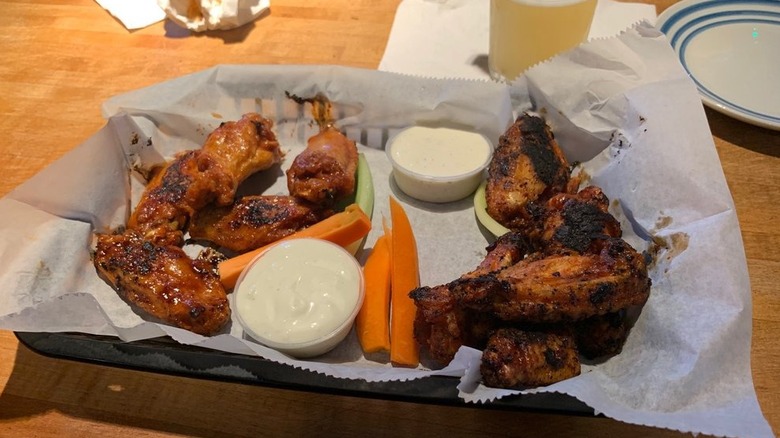 Basket of charred wings with ranch and carrot and celery sticks