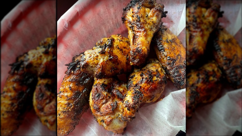 Plate of blackened wings on a piece of paper