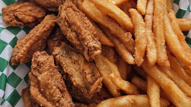 Fried chicken wings next to a pile of french fries