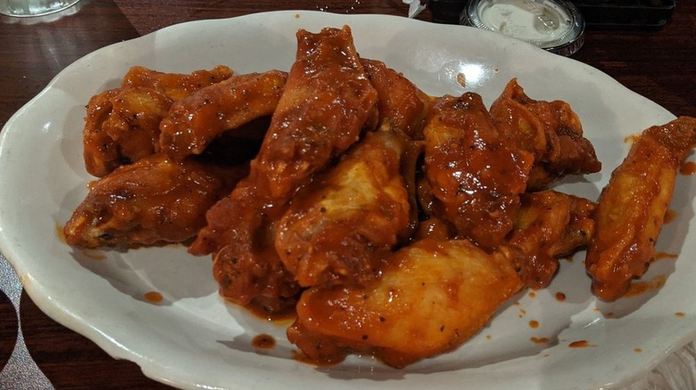 White plate full of saucy chicken wings