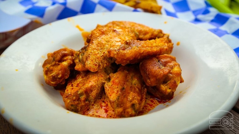 White plate of saucy chicken wings