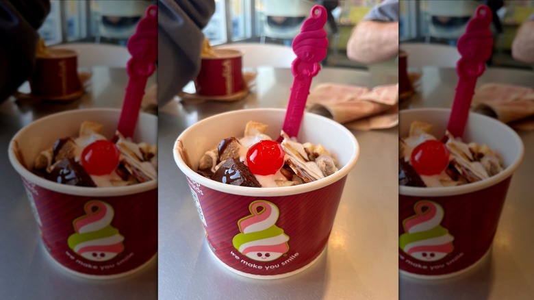 red cup of froyo with brownies, brittle, and a cherry