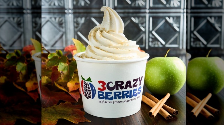 white paper cup with froyo swirl with apples and fall decor in background