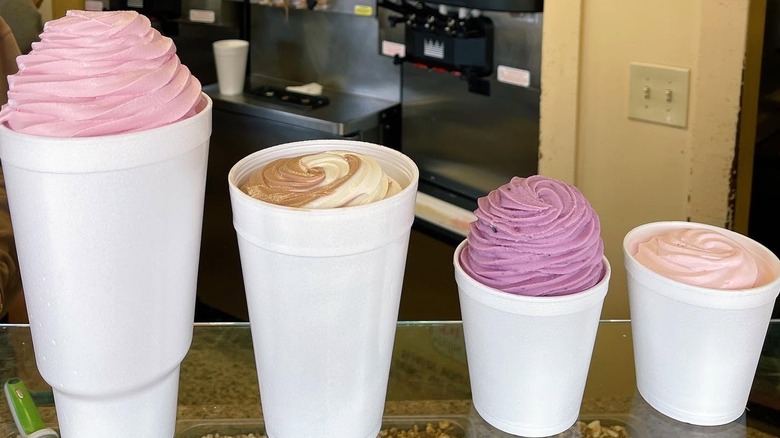 four large styrofoam cups full of froyo