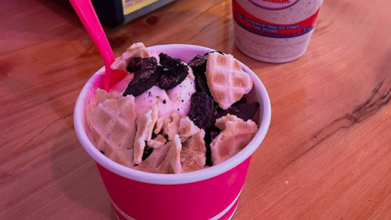 cup of frozen yogurt topped with waffle cone bits and oreo cookie crumbles