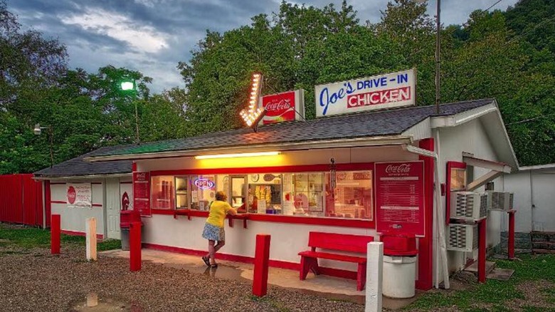 Exterior of Joe's Drive-In with woman ordering at the walk up window