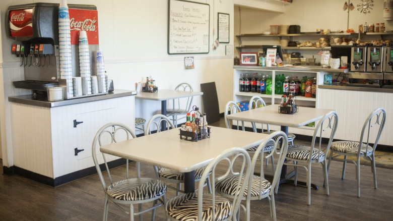 Interior of The Fill 'Er Up's dining area with tables and chairs and soda fountain machine