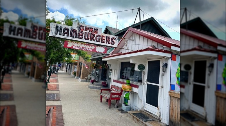 Exterior of The Whitehouse Restaurant next to sidewalk and faded open hamburgers sign