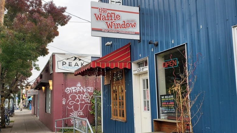 Exterior of Waffle Window with red striped awning and hanging sign