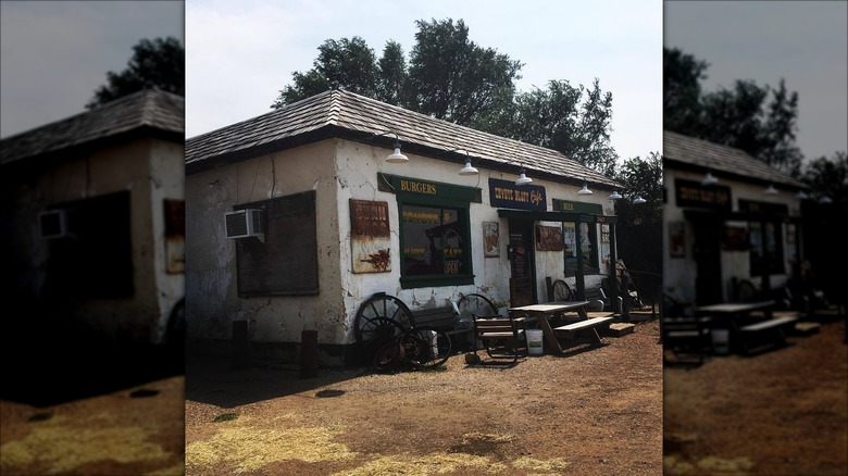 Exterior of Coyote Bluff Cafe with old timey wagon wheels resting on building side