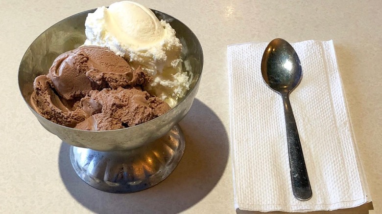 Steve's Homemade Ice Cream chocolate and vanilla ice cream scoops in silver dish with silverware on the side