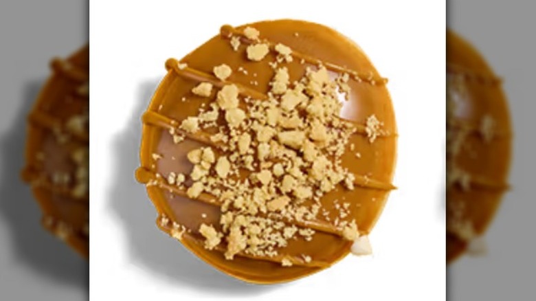 A top view of a Krispy Kreme Maple Cheesecake Doughnut on a white background.