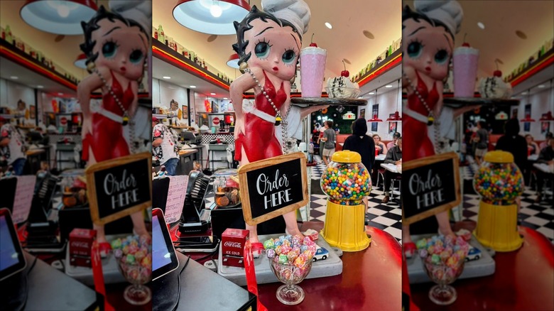 Interior dining room of Dan's Diner with Betty Boop statue and old school black and white checkered flooring