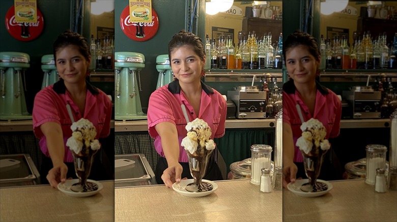 Soda Fountain counter with waitress in retro pink outfit serving a retro looking milkshake at MacAlpine's Diner & Soda Fountain
