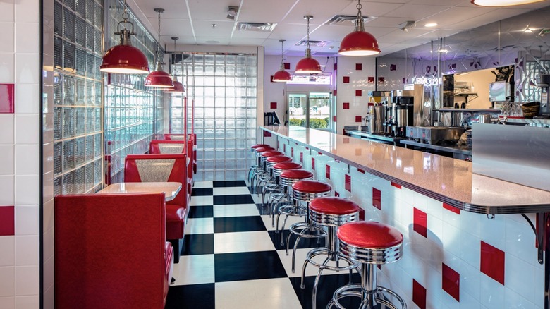 Interior of Goober's Diner with bright red booths and counter seating and black and white checkered flooring