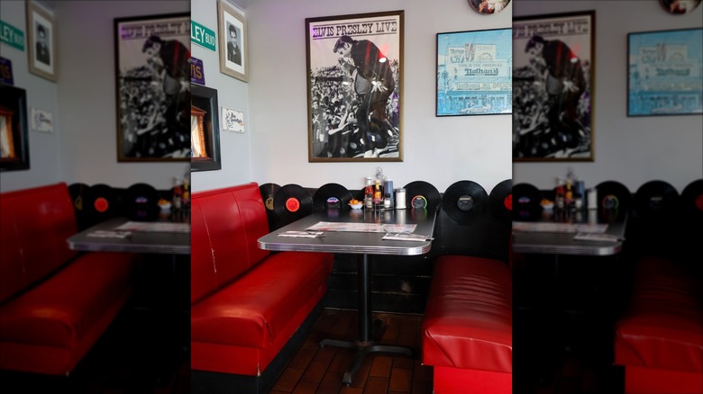 Bright red vinyl booth seating at Nelson's Diner with Elvis picture and vinyl records on wall as decoration