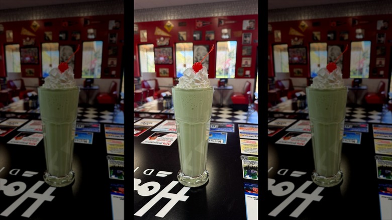 Up close photo of an old fashioned green milkshake with whipped cream and cherry at Hot Rod's Diner