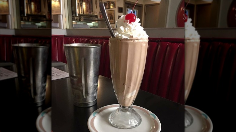 A chocolate milkshake topped with whipped cream and a cherry at South Side Soda Shop