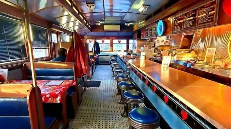 Interior dining area at A1 Diner with blue stools at counter seating and blue vinyl booths