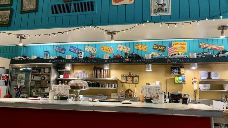 Interior counter with old fashioned license plates lining walls at Lost in the 50's Diner 